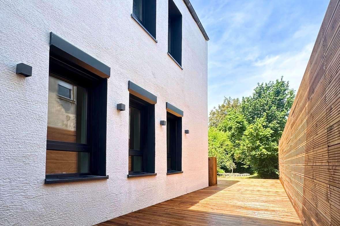 Sanierte Außenwand mit neuer Fassadenfläche und Holzverkleidung
