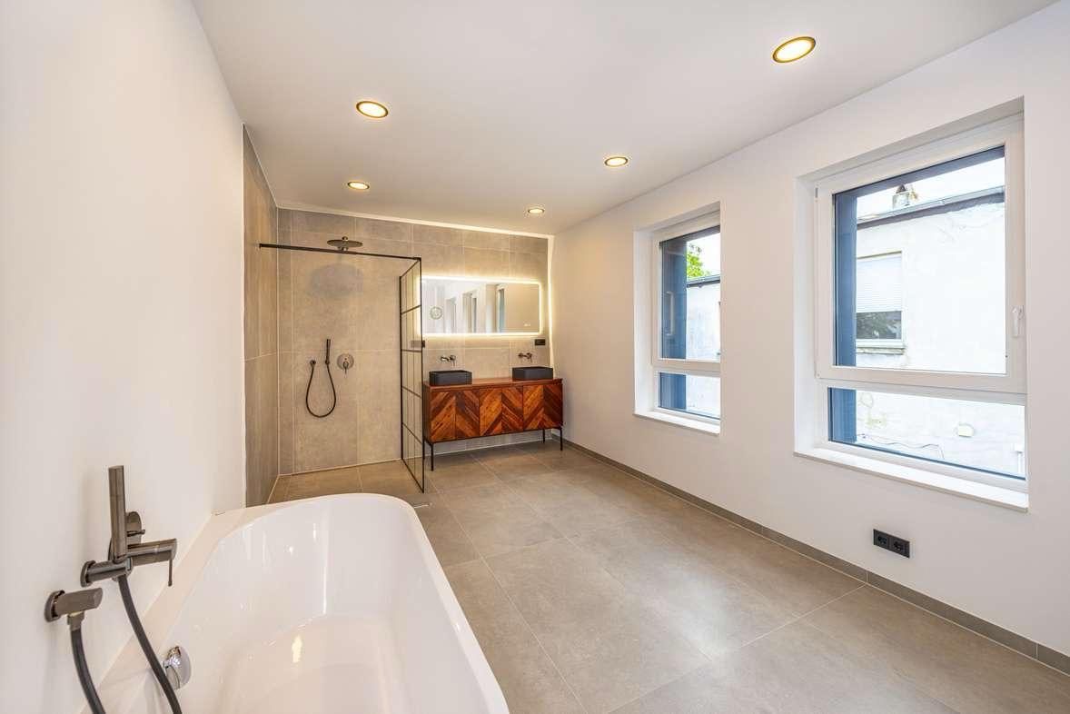Fertig saniertes Badezimmer mit bodengleicher Dusche und freistehender Badewanne